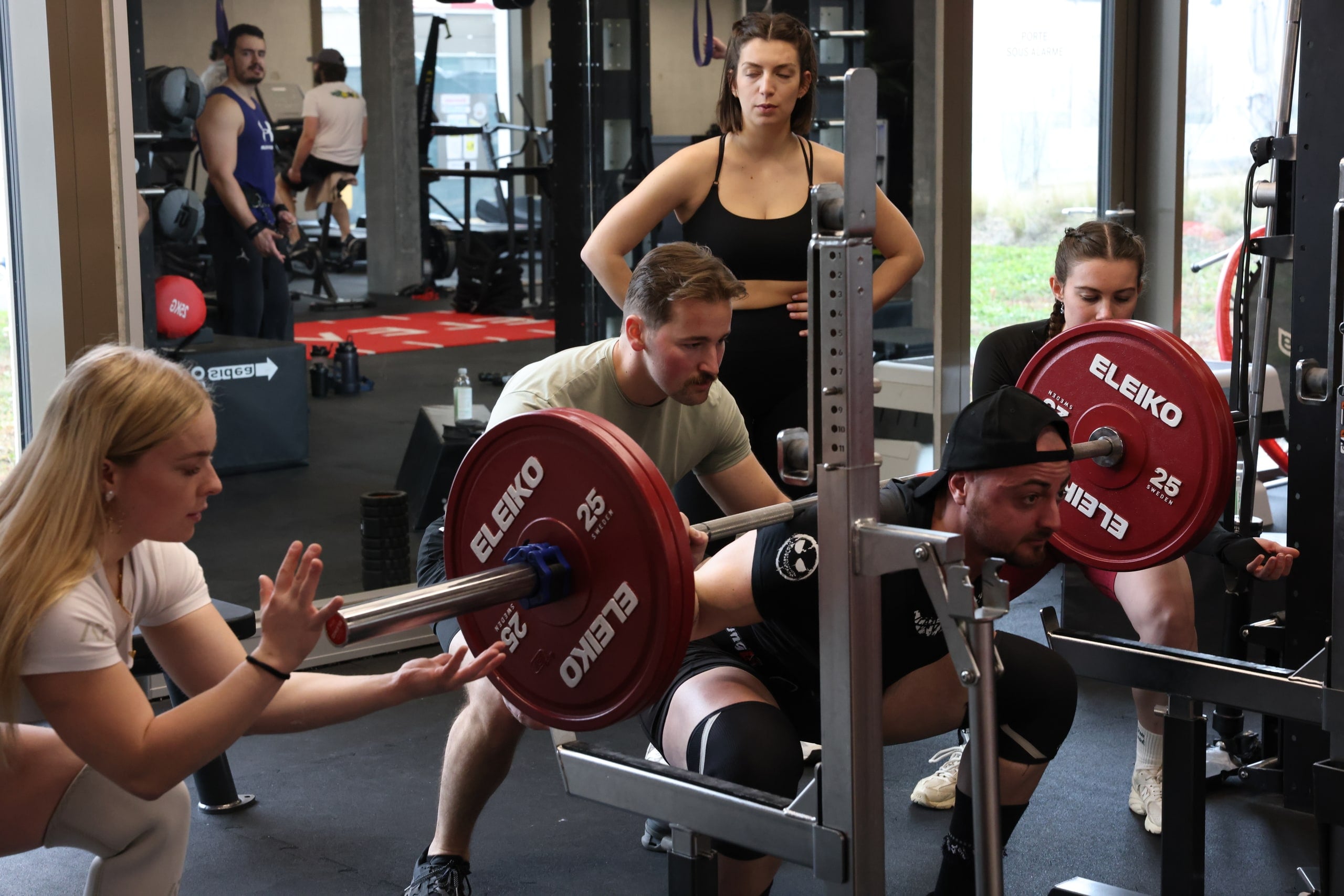 Heavy squat with spotters at a community event in Chavannes-près-Renens