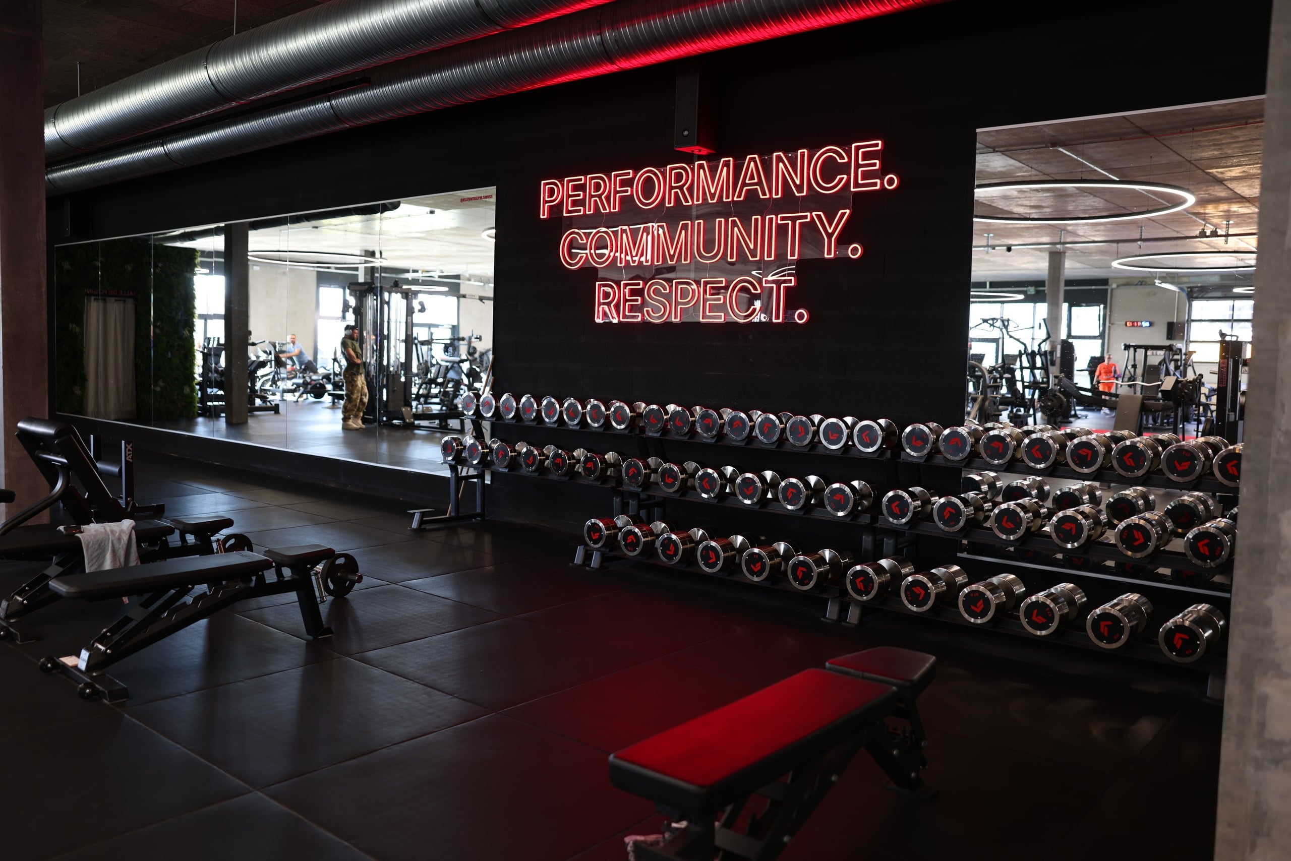 Néon Performance, Community, Respect au-dessus du rack d'haltères d'ELEVATE Gland